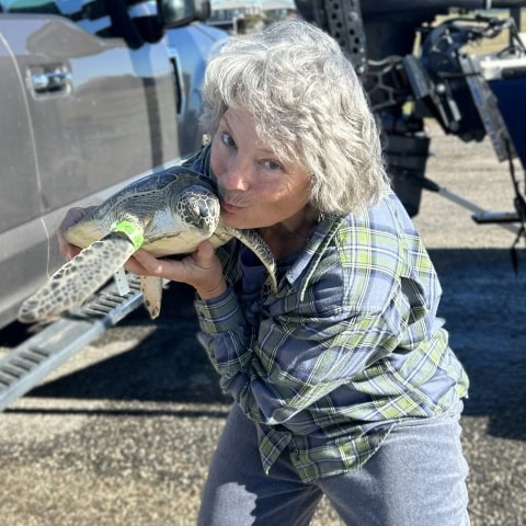 Brigid Berger with small green sea turtle