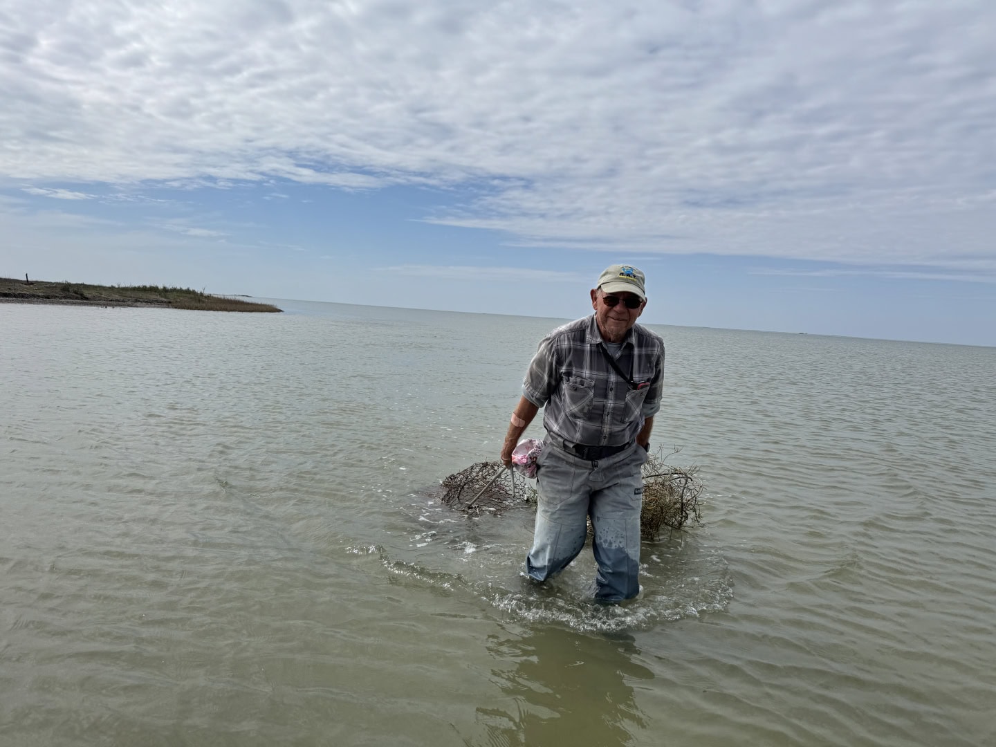 Allan Berger SABP chairman dragging abandoned crab traps in the water to a boat.