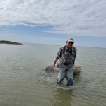 Allan Berger SABP chairman dragging abandoned crab traps in the water to a boat.